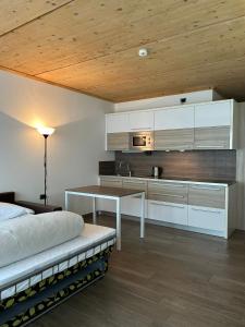 1 dormitorio con cama, mesa y cocina en Jolly Resort & Spa, en Ponte di Legno