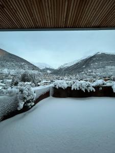a snow covered balcony with a view of a city at Jolly Resort & Spa in Ponte di Legno