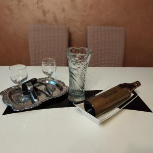 Una mesa con una botella de champán y copas. en Family Star apartman en Čačak