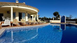 uma piscina com cadeiras e uma casa em Santo Antonio by Check-in Portugal em Albufeira