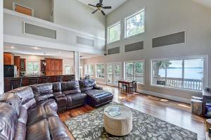 a large living room with leather furniture and windows at Family Lake House Retreat by AvantStay Sleeps 28 in Mooresville