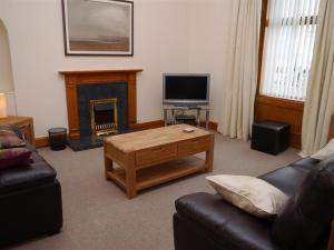 a living room with a coffee table and a fireplace at Number 48 in Dumfries
