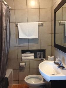 y baño con lavabo, aseo y toallas. en Motel Econonuit, en Sherbrooke