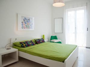 a bedroom with a bed with a green blanket at B&B Alcione in Pescara