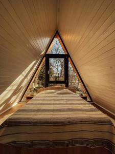 ein großes Bett in einem Zimmer mit Fenster in der Unterkunft Aret House in Avrig
