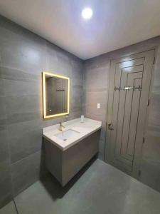 a bathroom with a sink and a mirror and a door at Luxury Suite in BF Homes in Manila