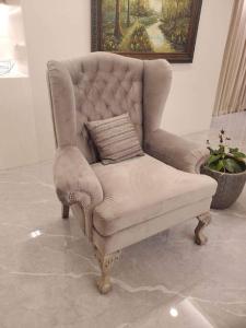 - une chaise blanche avec un oreiller dans l'établissement Luxury Suite in BF Homes, à Manille
