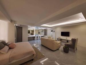a living room with a bed and a couch and a tv at Luxury Suite in BF Homes in Manila
