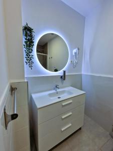 マドリードにあるオスタル ア ヌエストラ セニョーラ デ ラ パロマのバスルーム(白い洗面台、鏡付)