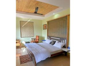 1 dormitorio con 1 cama grande y techo de madera en Kings Cottage, Bhimtal, en Bhimtal