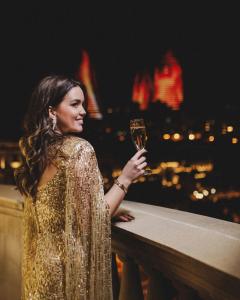 a woman holding a glass of wine on a ledge at Four Seasons Hotel Baku in Baku