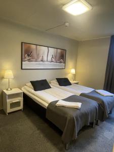 two beds in a hotel room with two towels on them at Hotell Briggen i Åhus in Åhus