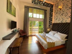 1 dormitorio con cama, mesa y ventana en DAN Resorts & Weddings en Boisar