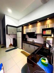 una cucina con elettrodomestici in acciaio inossidabile e piano di lavoro nero di Casa D JR Homestay a Ipoh