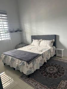 1 cama en un dormitorio con alfombra en Casa D JR Homestay, en Ipoh