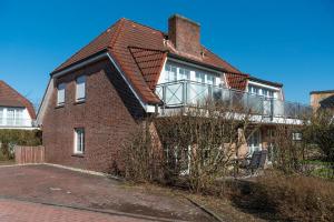 a brick house with a balcony on top of it at Gosewehr GbR in Hooksiel