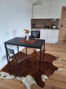 einen schwarzen Tisch und einen Stuhl auf einem Teppich in der Küche in der Unterkunft Exklusiv Appartement in Innsbruck