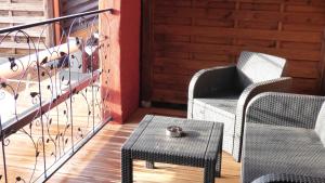 Dos sillas y una mesa en un porche con un tazón. en La Colline aux Yeux Doubs, en Baume-les-Dames