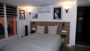 a bedroom with a white bed with a wooden headboard at La Colline aux Yeux Doubs in Baume-les-Dames