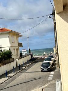 uma fila de carros estacionados numa rua junto ao oceano em Appartement vue océan em Capbreton