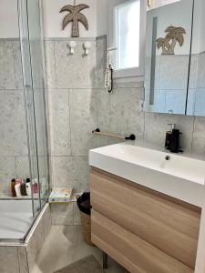 een badkamer met een witte wastafel en een douche bij Appartement vue océan in Capbreton