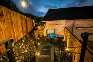 un patio trasero con bañera de hidromasaje al lado de un edificio en Stunning cottage Grade 2 listed with parking and Hot Tub en Bowness-on-Windermere