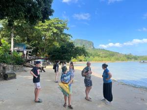 a group of people standing on a beach at Koh Mook Garden Beach Resort in Koh Mook