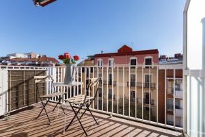 einen Balkon mit zwei Stühlen und einer Vase mit Blumen darauf in der Unterkunft Mercat Sant Antoni 4 in Barcelona