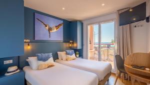 een hotelkamer met twee bedden en een balkon bij Résidence Kaliopé in Le Lavandou +65 foto's