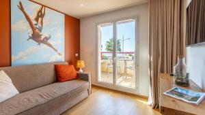 a living room with a couch and a large window at Kaliopé Résidences in Le Lavandou