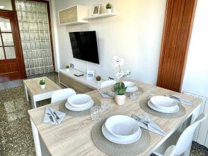 a dining room with a table with white plates at APARTBEACH EL CARRILET CENTRICO y LUMINOSO in Reus