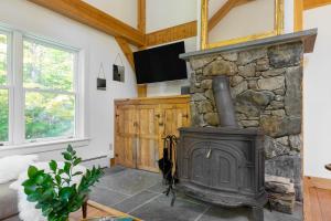 sala de estar con chimenea y pared de piedra en Woodfall by AvantStay Tons of Outdoor Space, en Monterey