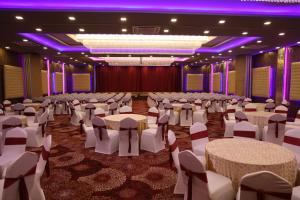 um hall com mesas e cadeiras numa sala com iluminação roxa em DAN Resorts & Weddings em Boisar