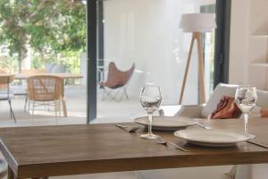 a wooden table with two wine glasses on it at Villa des jacinthes in Tarascon