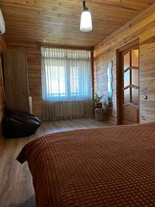 ein Schlafzimmer mit einem Bett in einer Holzhütte in der Unterkunft Ранчо, Дом для релакса в окружении леса и озёр in Kolonshchina