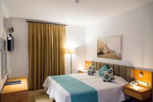 Habitación de hotel con cama y ventana en Kefalos Beach Tourist Village, en Pafos