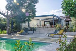 a house with a swimming pool and chairs next to a house at Villa des jacinthes in Tarascon