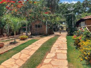a stone path in a garden with trees and flowers at Ranchos 30 Hotel Fazenda in Hidrolândia