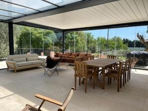a patio with a table and chairs and a couch at Villa des jacinthes in Tarascon