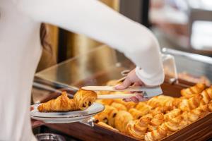 a person reaching for a plate of food at Apollinaire Nice, WorldHotels Distinctive in Nice