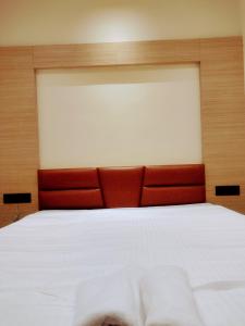 a bedroom with a large white bed with a red headboard at HOTEL SKYKING in Gauripur