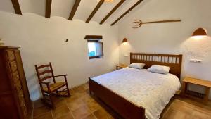 1 dormitorio con 1 cama y 1 silla en Casa de La Abuela, en Taberno