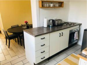 a kitchen with a counter and a table with a microwave at Serenity Cottage in Benoni