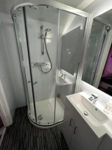 a bathroom with a shower and a sink at Royal Snug & Wee Snug in Kincardine OʼNeil