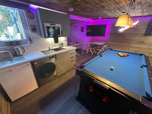 a kitchen with a pool table in a kitchen with purple lighting at Royal Snug & Wee Snug in Kincardine OʼNeil