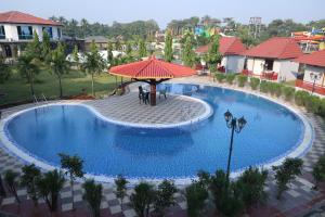 an overhead view of a large swimming pool with an umbrella at DAN Resorts & Weddings in Boisar