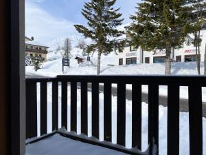 uma vista a partir de uma varanda de uma rua coberta de neve em Fiocco di Neve Home em Passo del Tonale