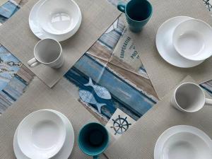 a table with white plates and cups on a table at Monolocale La Conchiglia in Sestri Levante