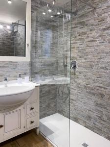 Un baño con ducha de cristal y lavabo. en Fiocco di Neve Home, en Passo del Tonale 21 fotos más