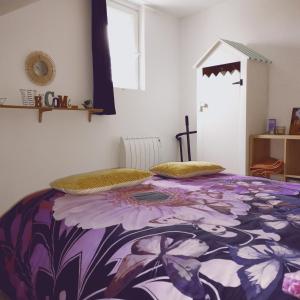 1 dormitorio con 1 cama con una manta colorida en Longère de charme au calme de sa campagne environnante, en Marigné-Laillé